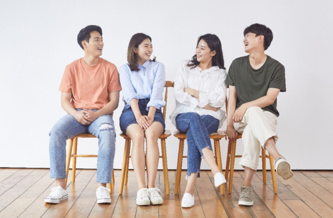 청년들이 의자에 앉아 밝게 웃고 있다.