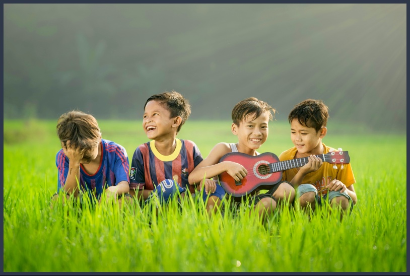 잔디 밭에 앉아있는 어린이 4명