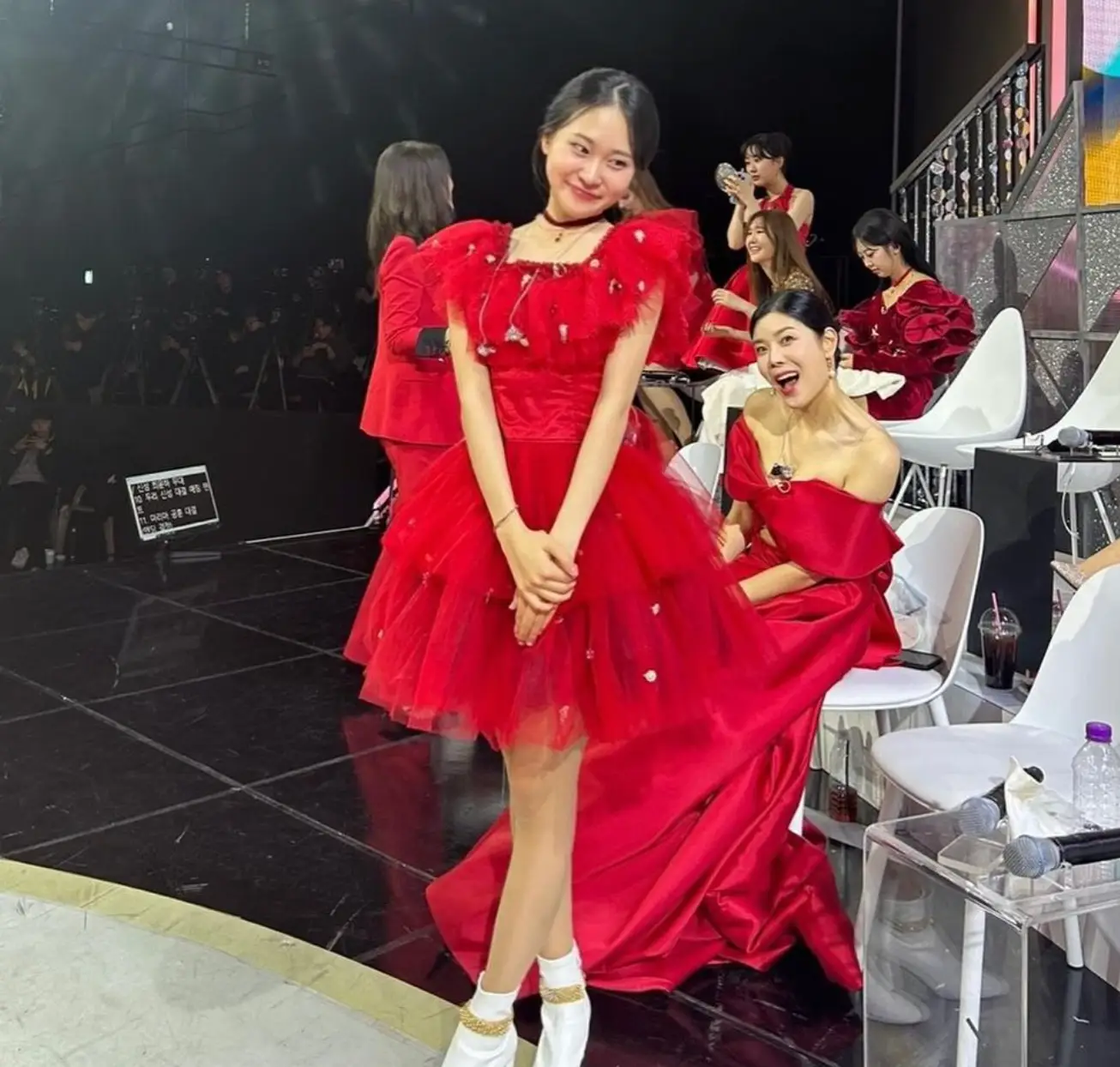 한일-검은 무대위 빨간 원피스를 입고 귀여운 포즈를 취한채 서있는 김다현