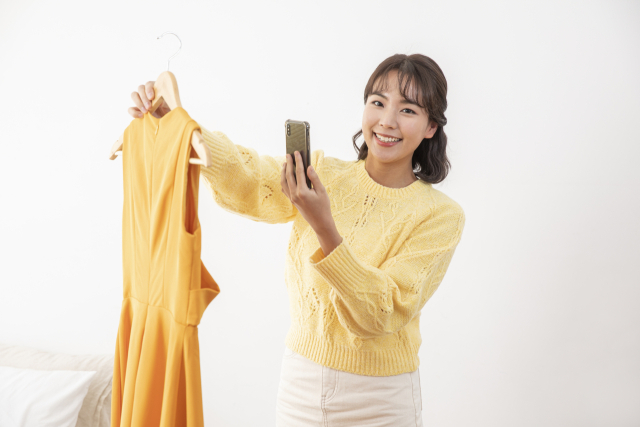 한 소비자가 중고 의류를 거래하고 있다.