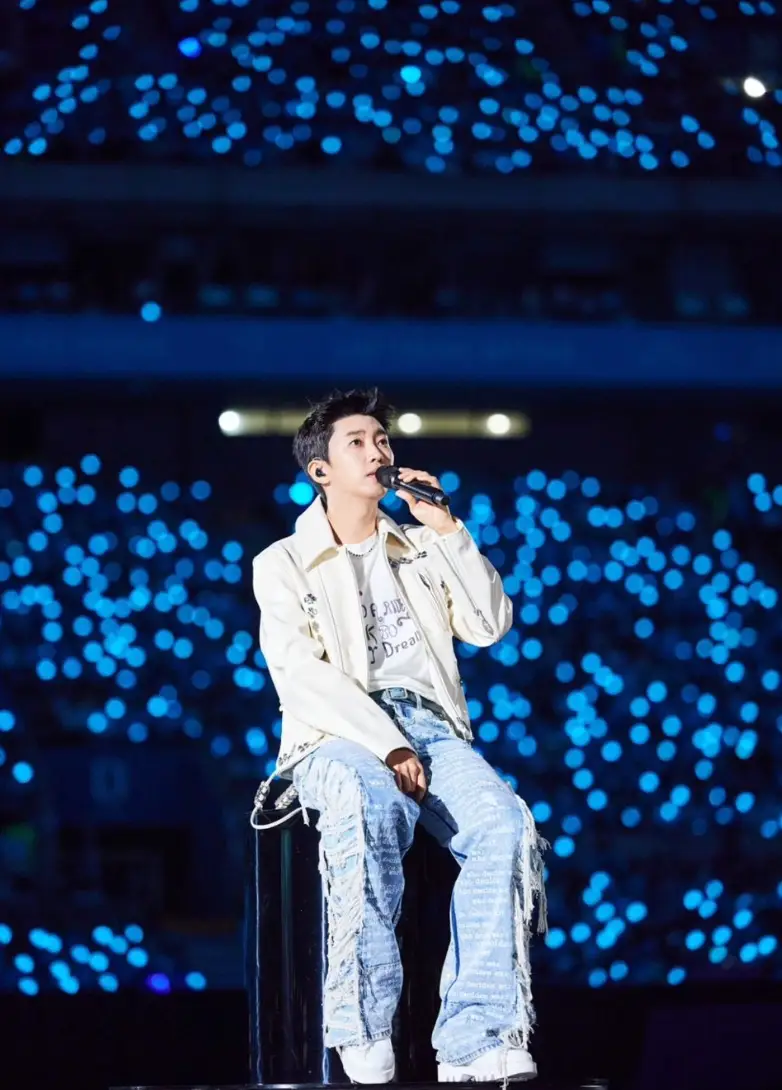 파란 불빛을 뒤로하고 흰자켓 청바지를 입은 임영웅이 의자에 앉아 노래하고 잇는 임영웅