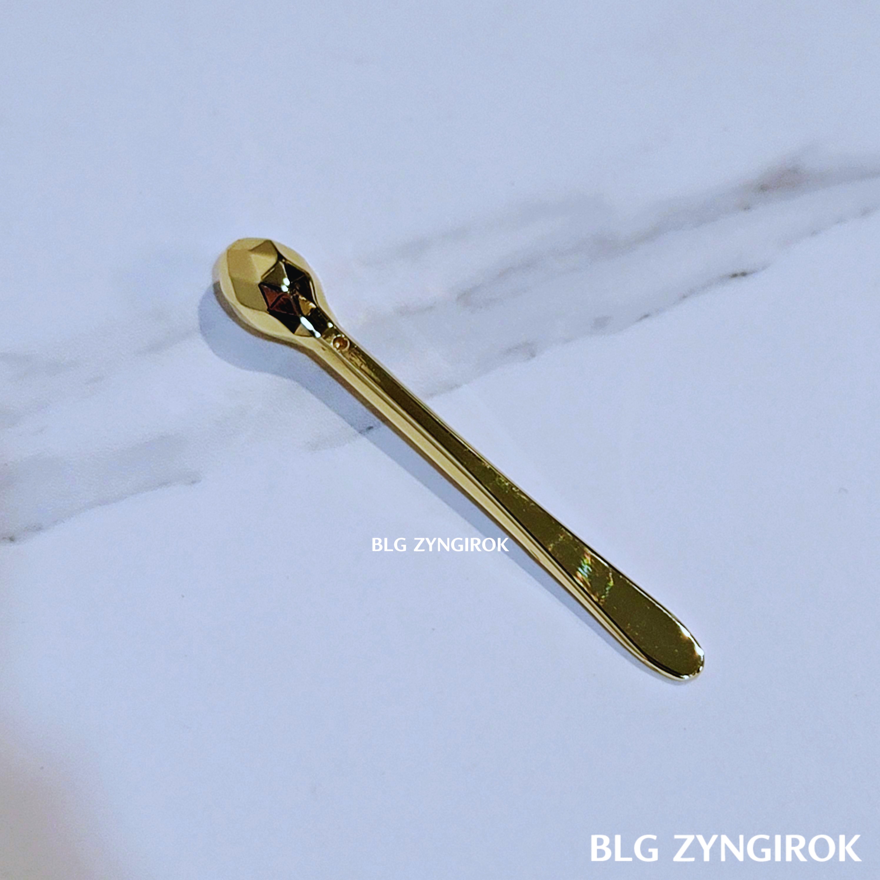 크림을 옮길 때 사용하는 금생 숟가락이 테이블 위에 놓여있다.