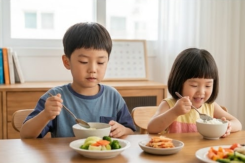 채소 반찬 위에서 숟가락을 멈춘 아들과 밥 먹는 딸
