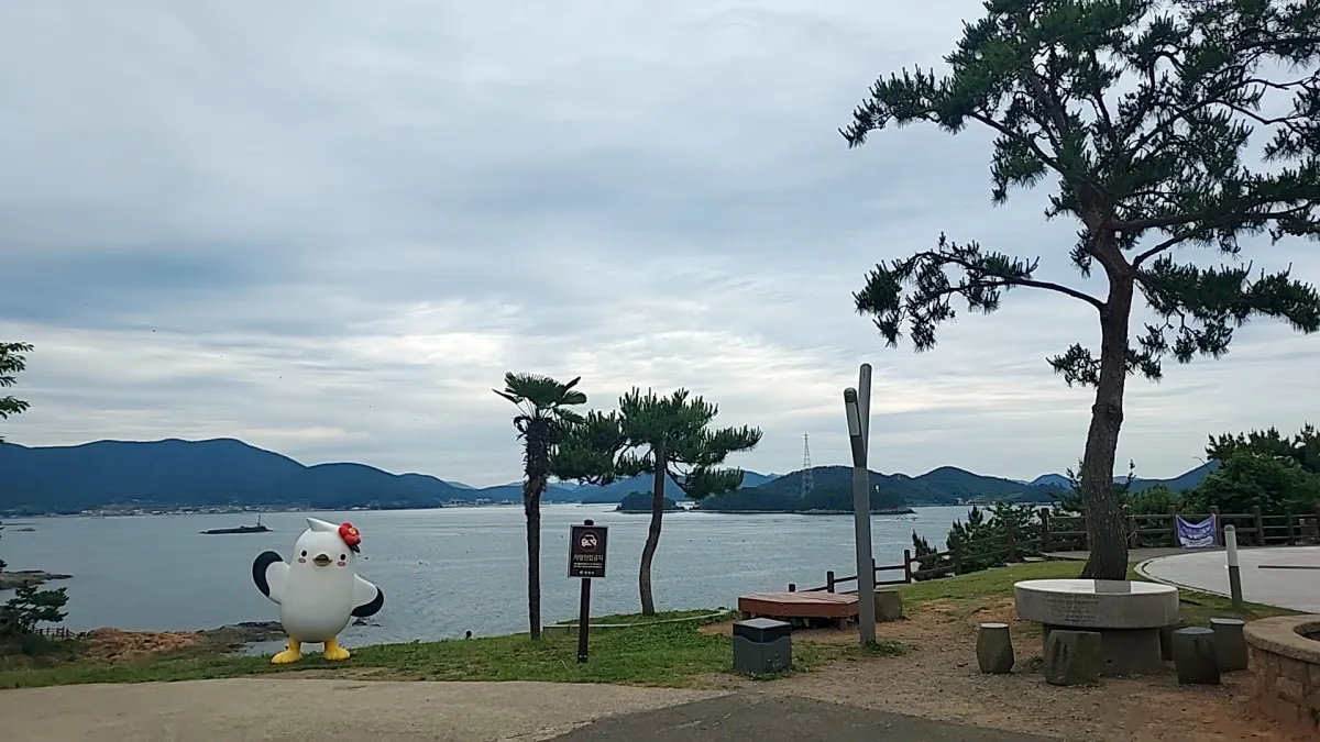 통영-이순신공원-소나무-벤치-조형물-바다-바다에떠있는배한척-멀리보이는섬-푸른하늘