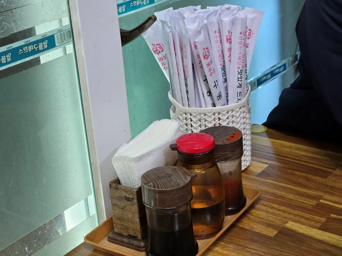 테이블 위 나무젓가락과 식초, 고춧가루 세팅된 모습