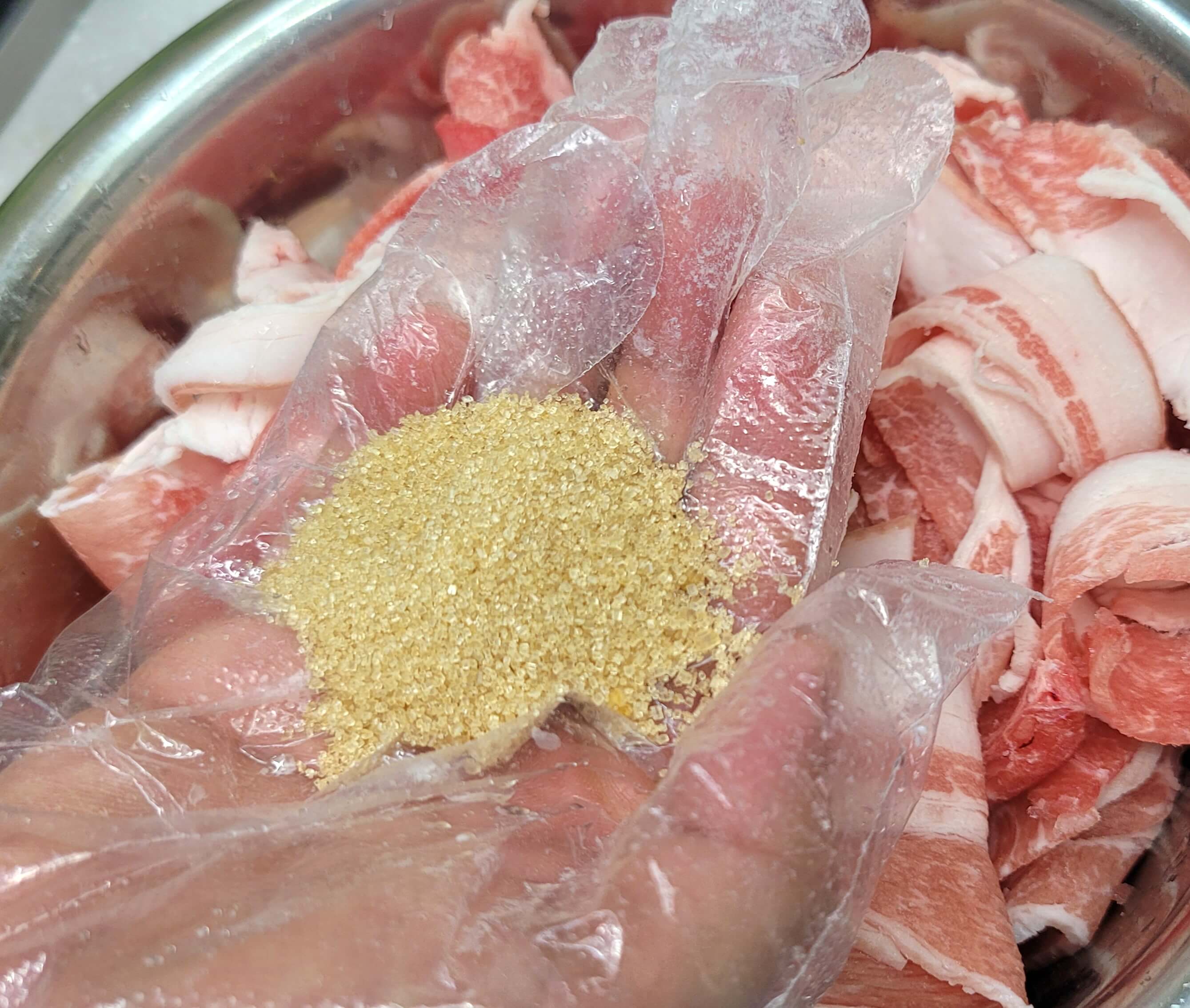 제육볶음을 위한 대패 삼겹살 위에 설탕을 뿌려 재워두는 준비 과정