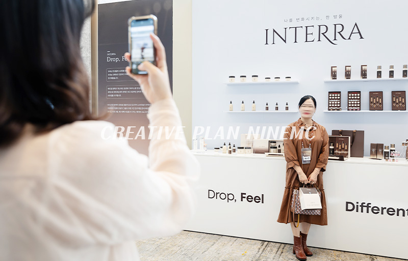 VIP 대상 런칭행사에서 브랜드 제품 진열 앞 사진 촬영하고 있는 장면