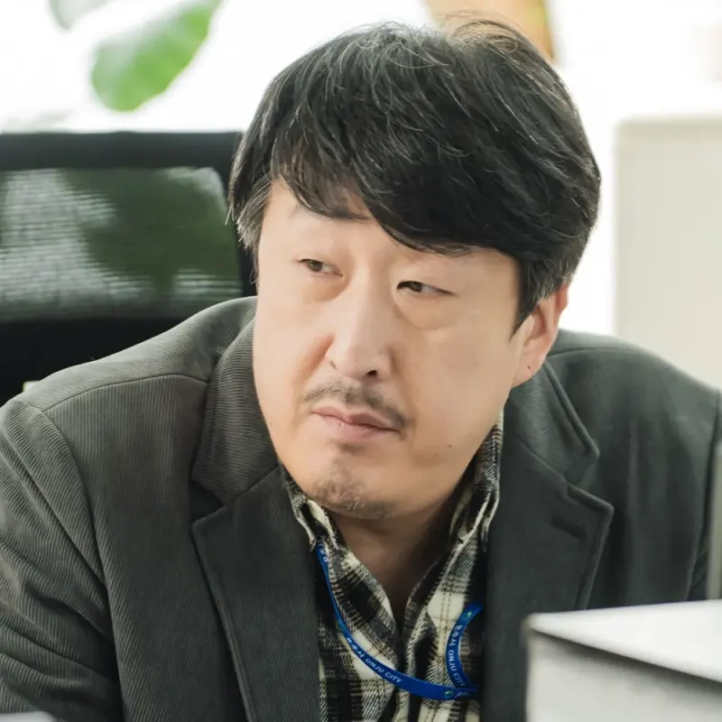 사무실 책상에 쥐색 자켓을 입고 새치와 콧수염이 수더분하게 있는 드라마 이 연애는 불가항력의 공서구 캐릭터