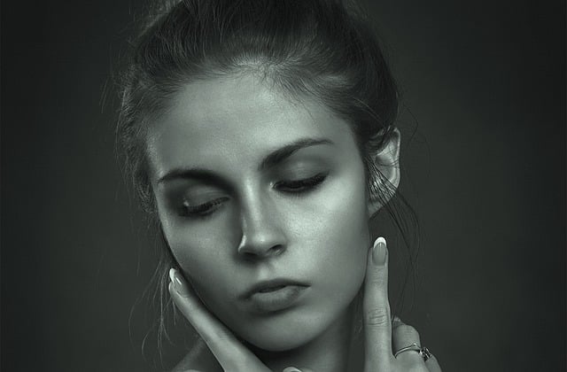 시선을 아래로 보고 있는 여성의 정면 얼굴 사진.