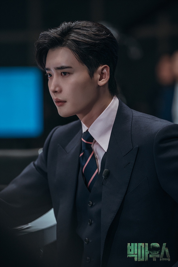 정장 차림으로 앉아 있는 빅마우스 박창호의 현장 스틸