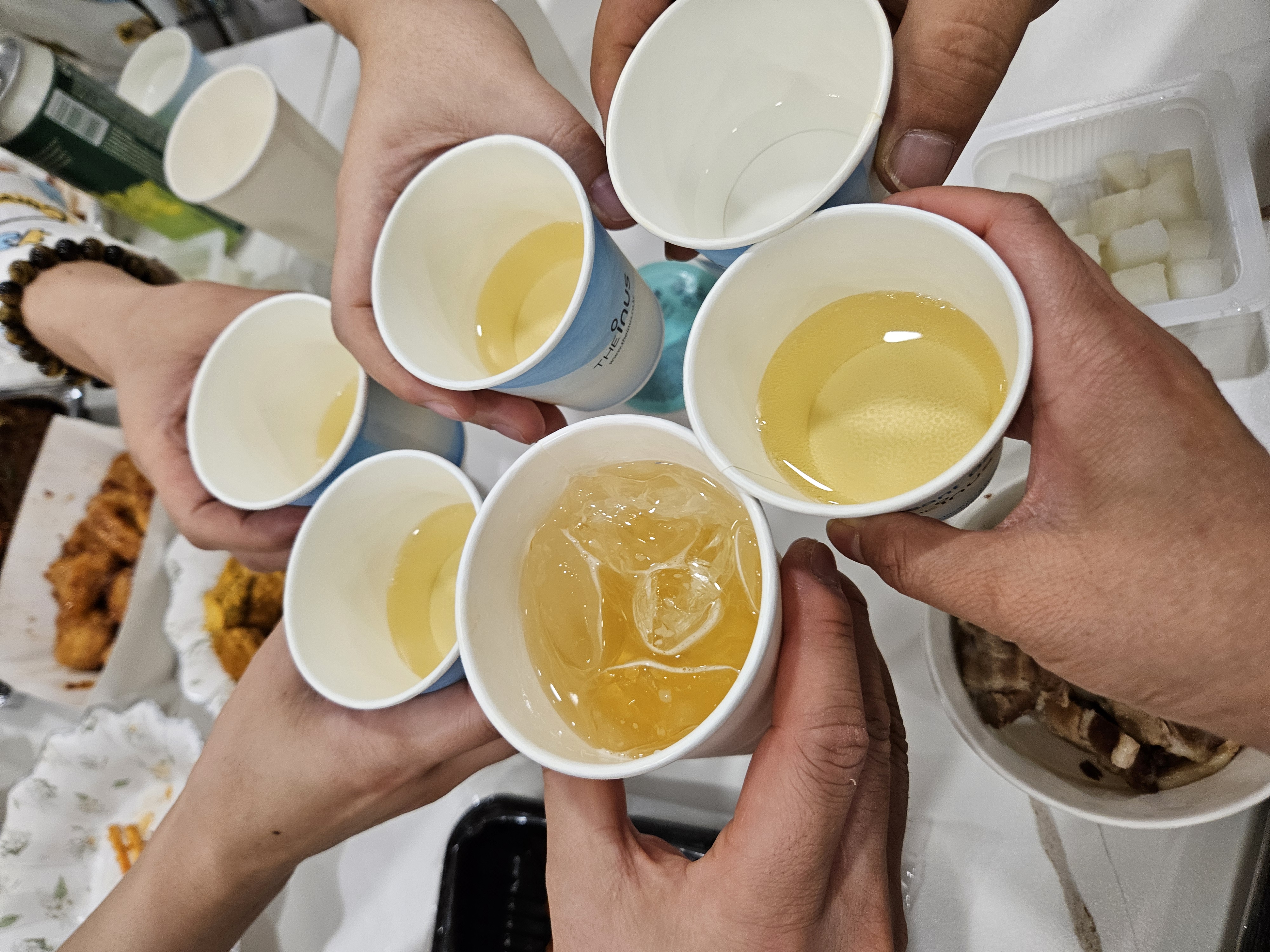 유리잔에 담긴 하이볼을 들고 건배하는 가족들의 손