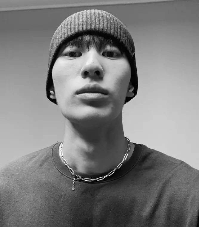 솔로지옥 3 - 흑백사진에 반팔티를 입고 스틸소재 목걸이를 하고 비니모자를 쓴 채 턱을 들고 아래를 내려다 보고있는 최민우