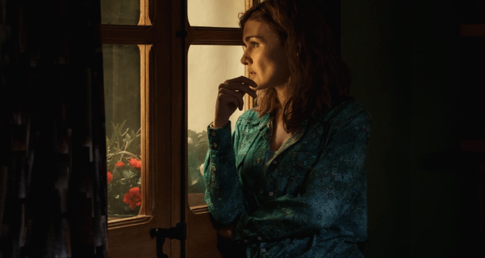 문에 기대어 뭔가를 바라보는 여성의 모습