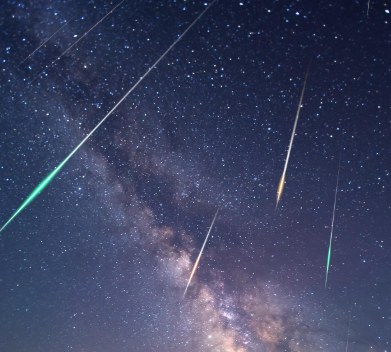 밤하늘에 수많은 유성이 별빛 사이로 떨어지는 장면