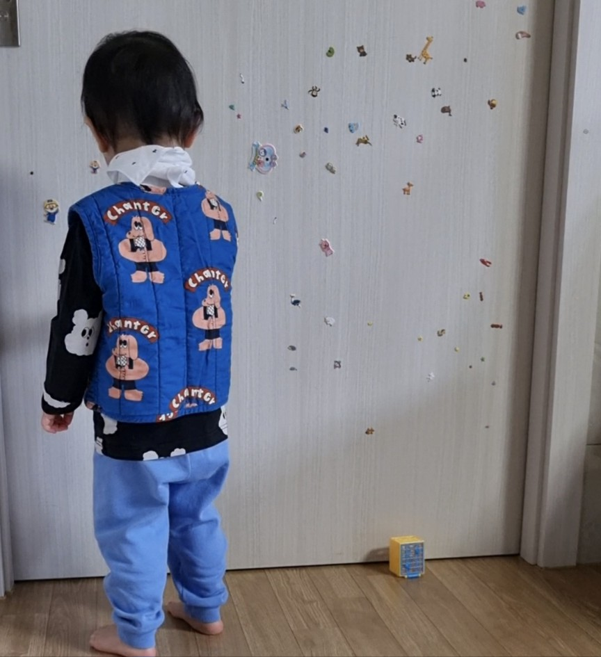 21개월 아기가 방문에 알록달록 깨알 스티커를 붙이고 서있는 뒷모습