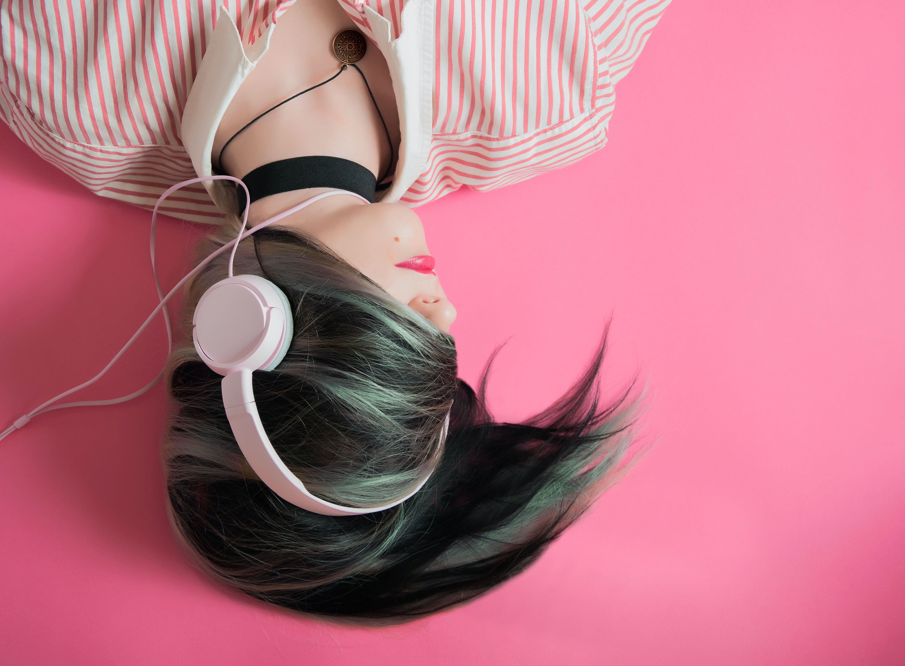 A stylish woman listening to music while wearing a headset