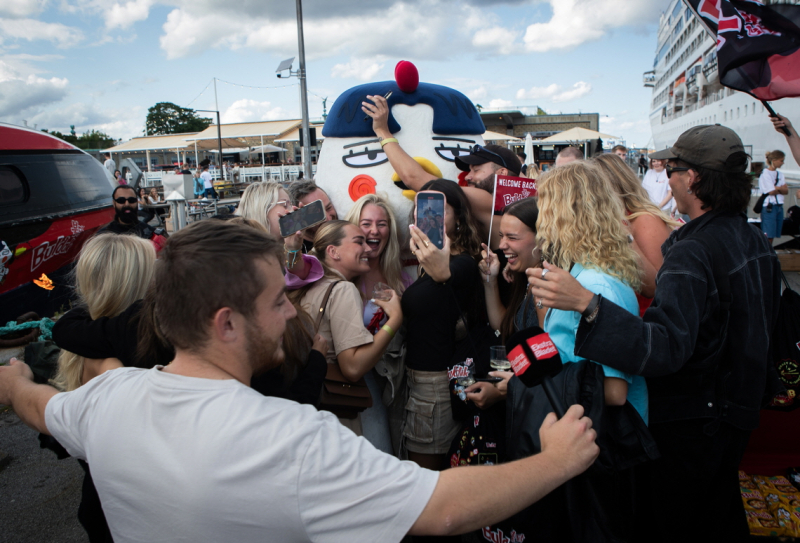 불닭 캐릭터 &lsquo;호치&rsquo;와 해외 팬들이 사진을 찍고 있다.