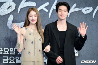 드라마 착한 사나이 남녀 주인공이 서로 팔짱을 낀 채 앞을 보며 손을 흔들고 있다.