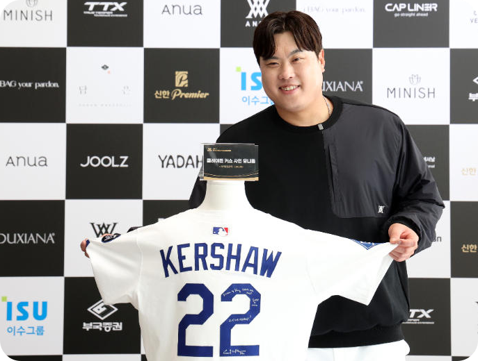 한화 투수 류현진이 전 LA 다저스 투수 클레이턴 커쇼가 선물한 사인 유니폼을 경매품으로 기부한 뒤 기념 촬영하고 있다. [사진=연합뉴스]