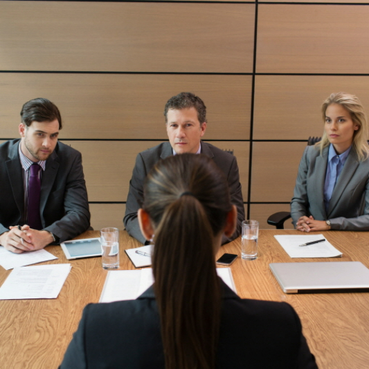 세 명의 면접관이 한 명의 면접자와 마주보고 있습니다.