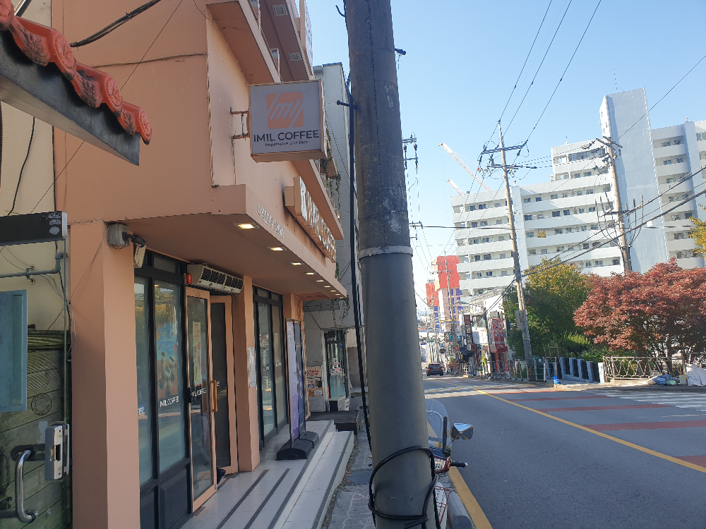 카페 측면 연한 오렌지 컬러의 파사드와 간판