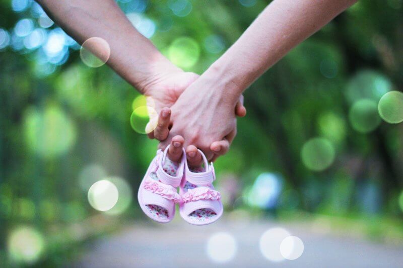 손을-맞잡고-아기신발을-들고있는-모습