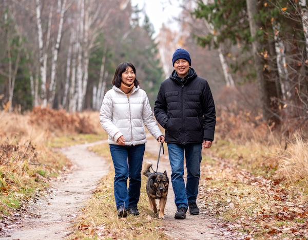 가족이 반려견과 자연휴양림을 산책하는 모습