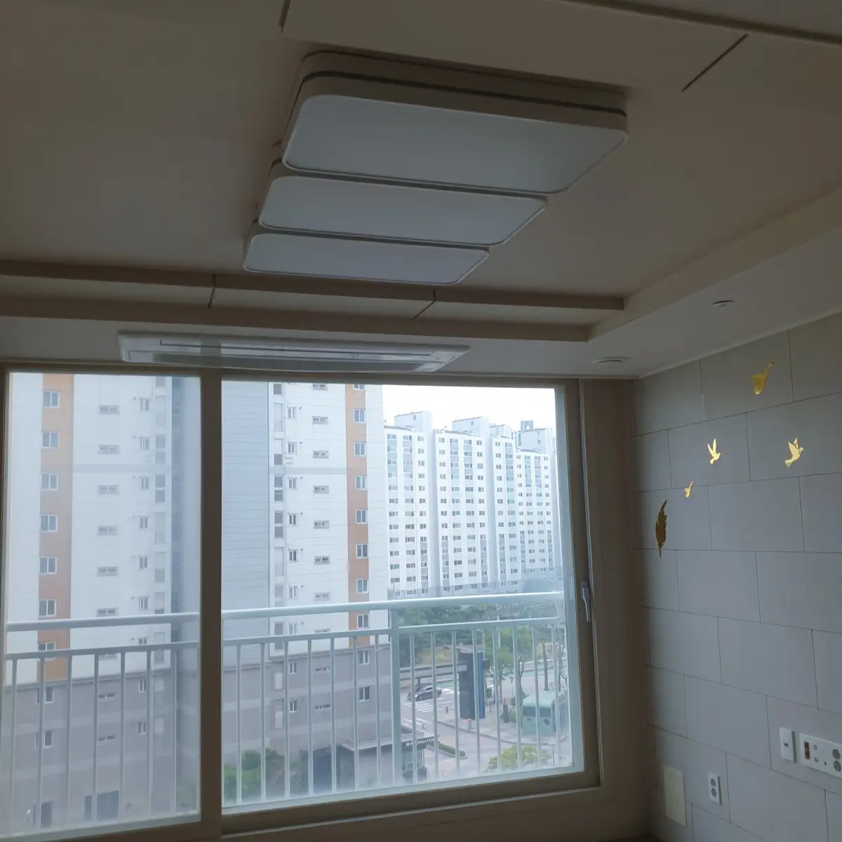 아파트-거실-시스템에어컨-천장-조명-베란다