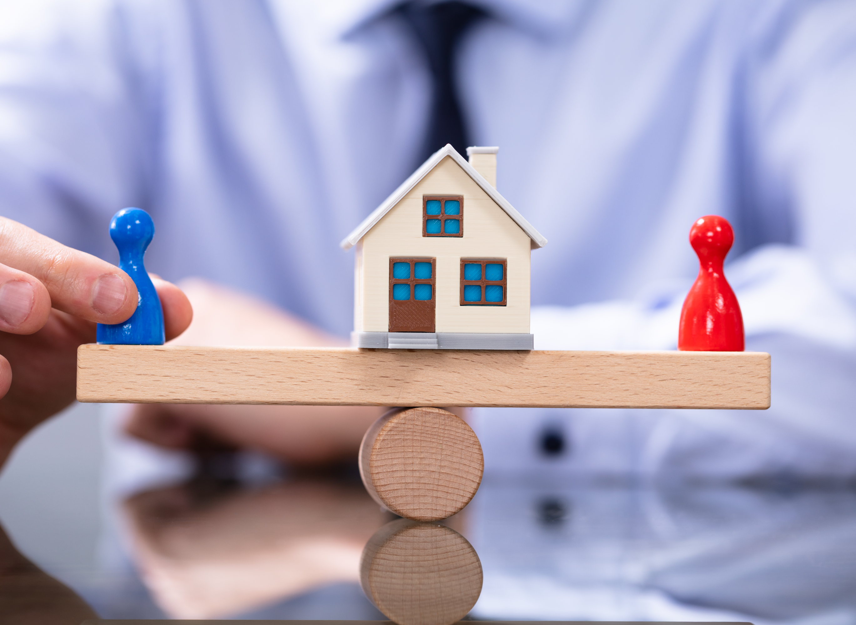 별거 중 재산분할에서 부부가 주택을 두고 대립하는 상황을 상징하는 이미지로, 재산 균형을 저울처럼 표현함