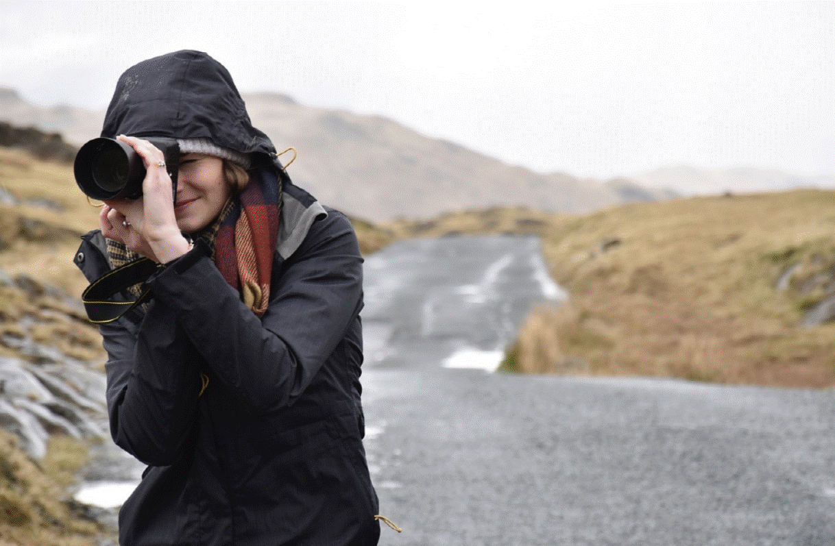 한 여성이 카메라를 들고 사진 찍는 사진