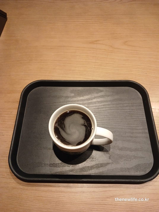 작업용 책상 위에 놓인 뜨거운 블랙커피 한 잔, 집중력 향상을 위한 커피 타임