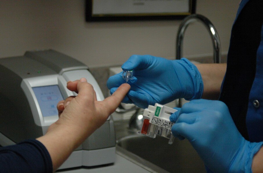 의사가 환자의 혈당을 재기 위해 채혈하는 모습