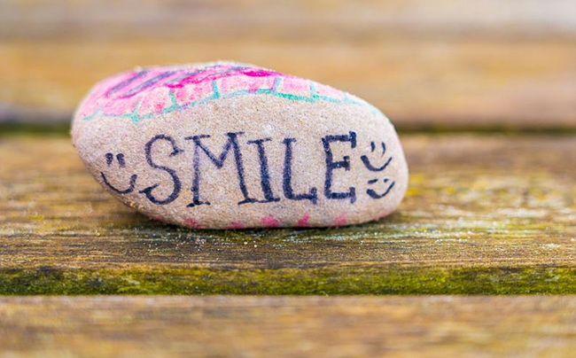 돌에 smile 영문이 쓰여진 사진