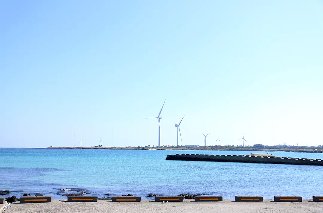코스 후반부 평대해변에서 바라본 풍력 발전기와 에메랄드빛 바다 풍경 사진.