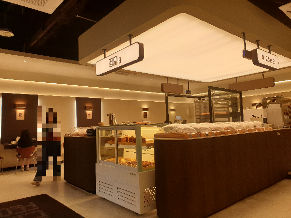 중앙에 크게 놓여 있는 베이커리 존. 베이커리 존 위쪽에는 간접 조명으로 더 눈길을 높인다.