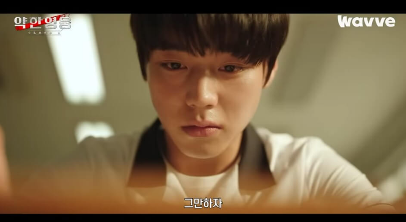 박지훈이 책상위를 내려다보는 모습