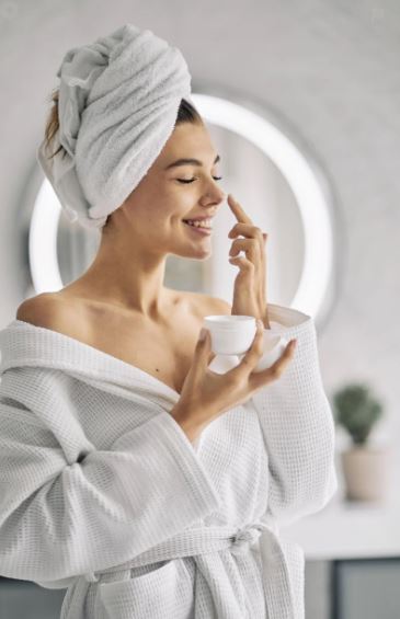 여성이 집에서 피부관리하는 사진 크림을 얼굴에 찍어바르는사진