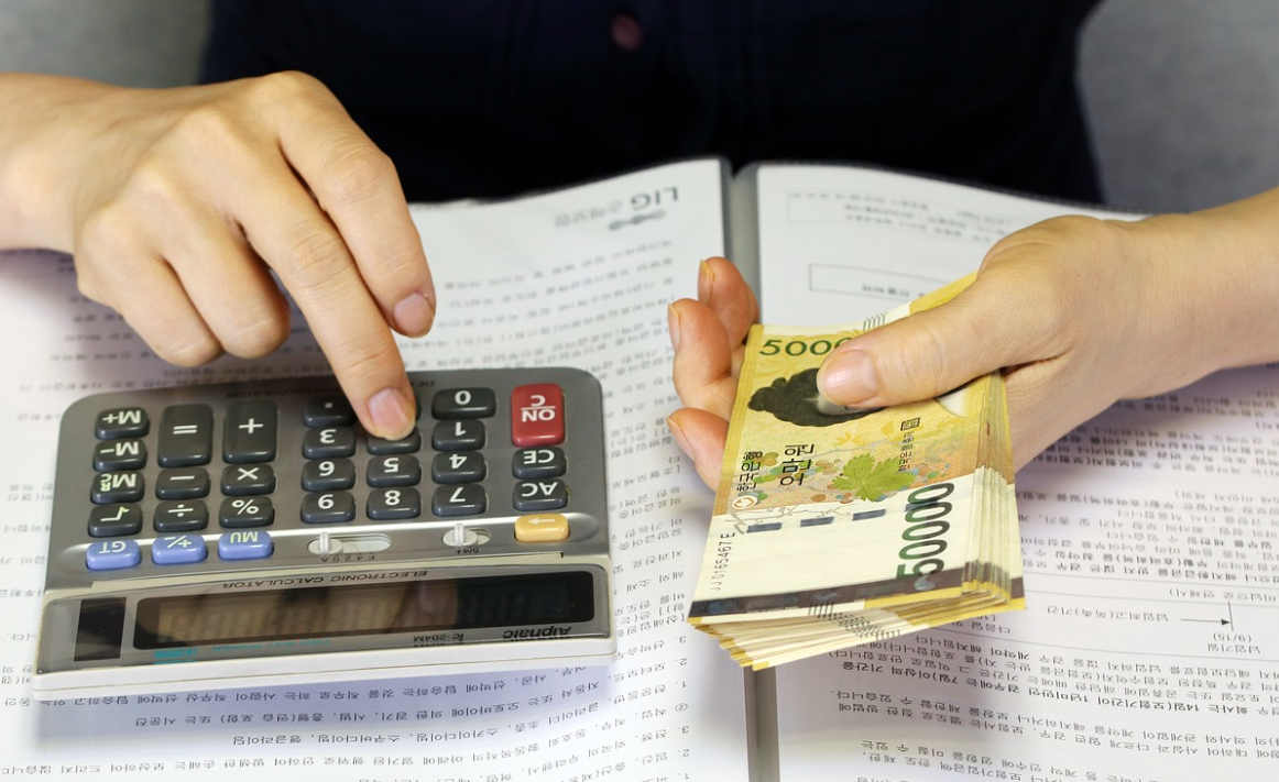 5만원짜리 돈다발을 들고 계산기를 든 손