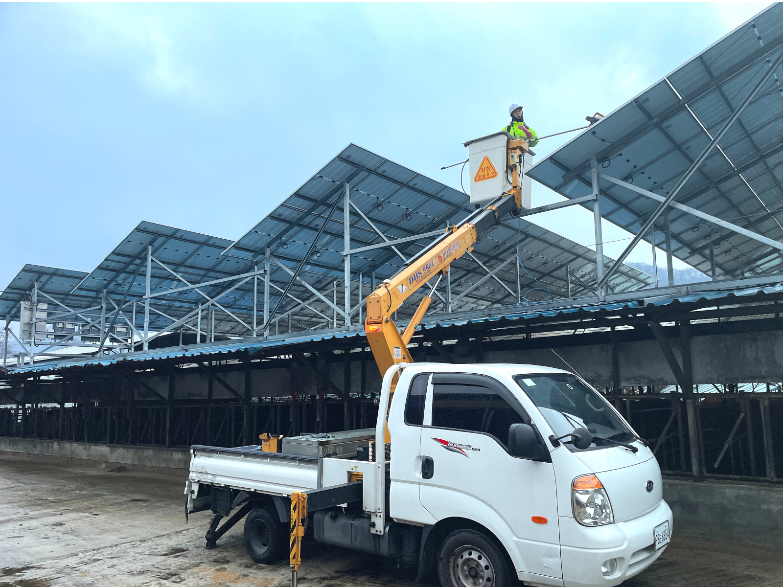 축사 위 태양광 패널과 하얀색 트럭