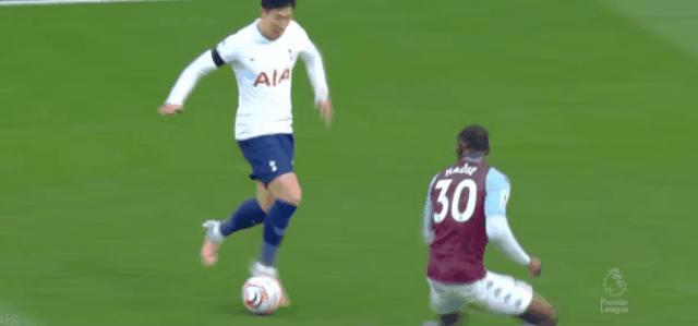 손흥민 선수가 느리게 드리블하다가 순간적으로 스피드를 올려 상대 수비를 제치며 슈팅하고 있다