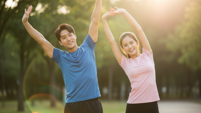 건강한 남녀가 햇살 아래 웃으며 스트레칭하는 장면