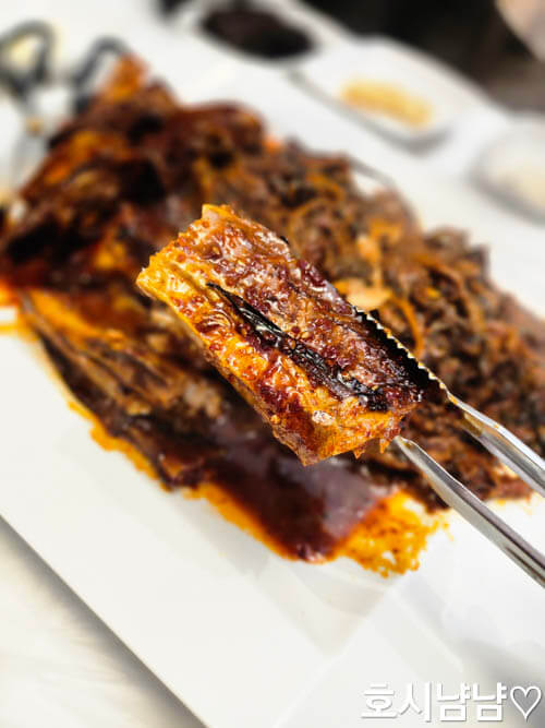 코다리덕장 코다리조림 근접샷, 집게로 코다리 살을 들어 올린 장면