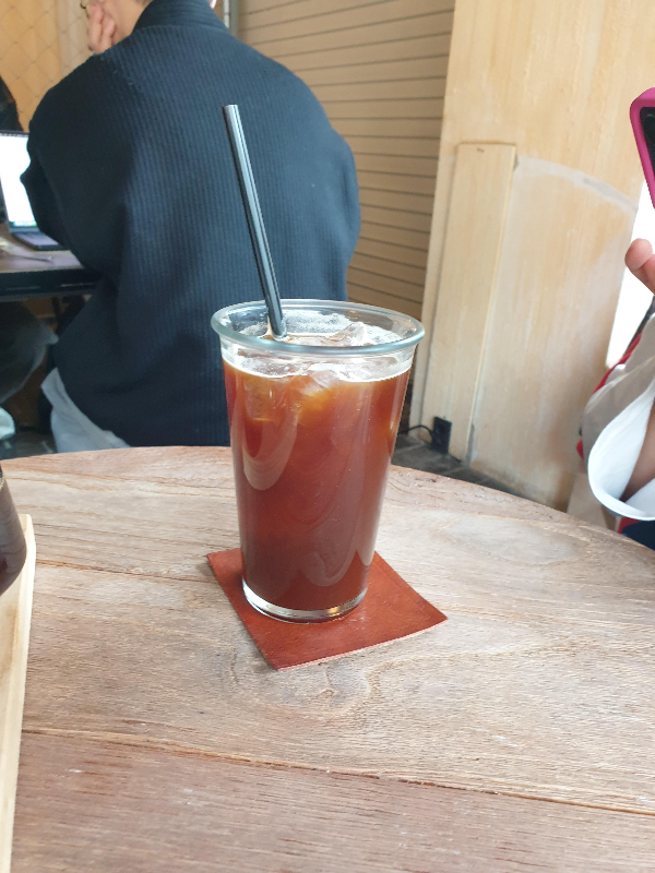 아이스 아메리카노에 검은 빨대가 꽂혀서 서빙 됨