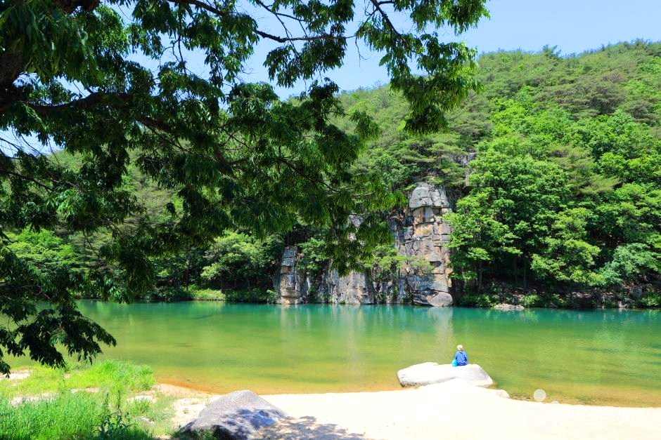 계곡에 한 여인이 앉아있다.