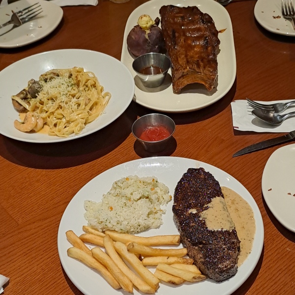 식탁에 파스타, 스테이크가 있어요