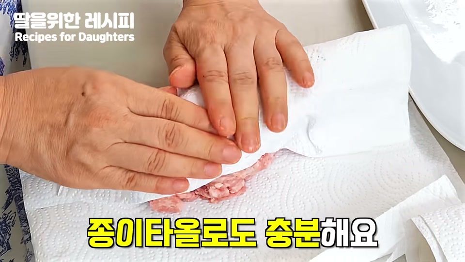 키친타월로 고기의 핏물을 닦아내는 장면