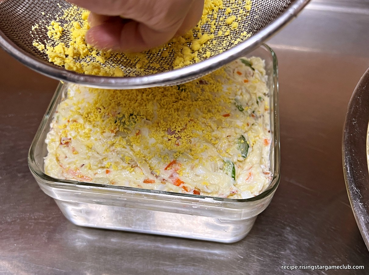 샐러드 빵 (사라다 빵)에 들어갈 완성된 샐러드를 밀폐용기에 담아 그 위에 계란 노른자를 토핑하는 사진