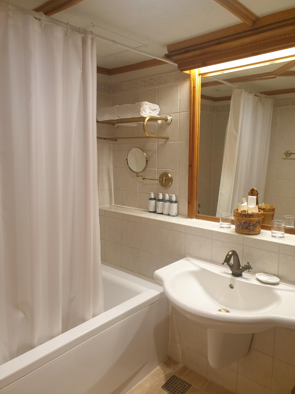 아이보리 컬러의 타일로 이뤄진 욕실, 욕조가 있다. 커튼으로 요조를 구분해놨다.