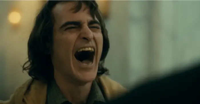 영화 <조커>의 한 장면, 과한 웃음에서 본능적으로 부정적 에너지가 느껴진다.