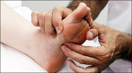 발바닥 통증이 있는 곳을 마사지하는 모습